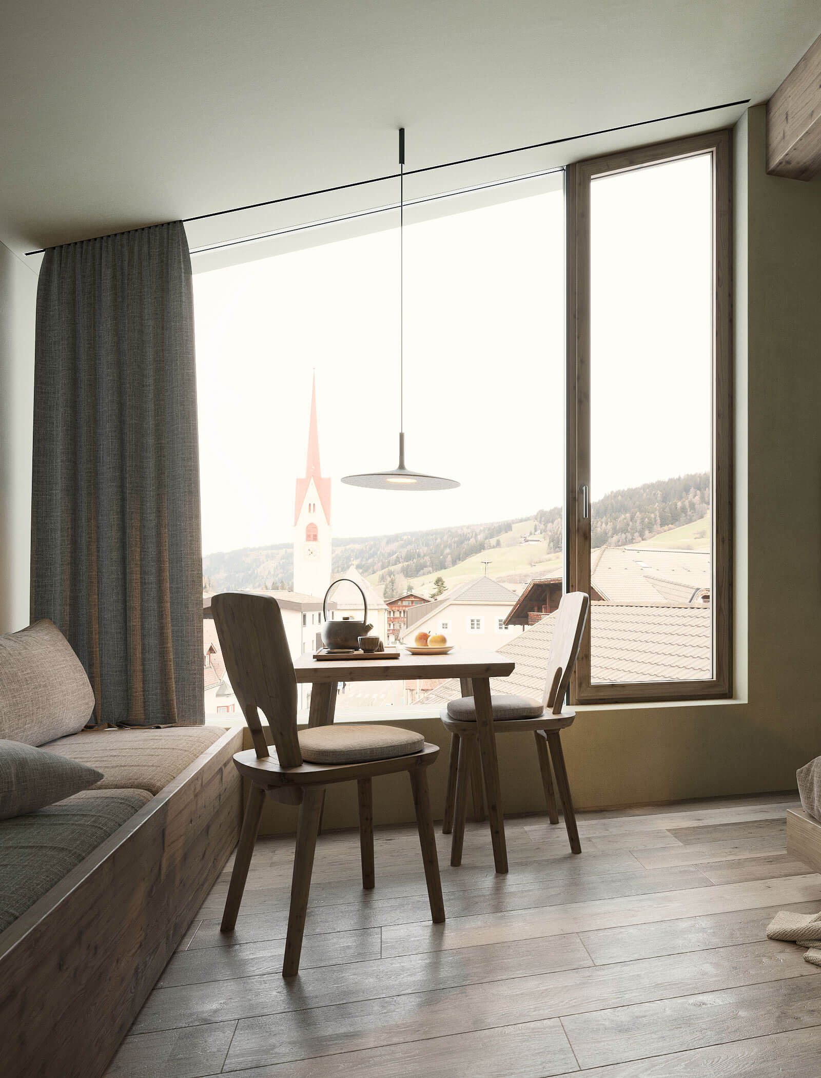 Eine gemütliche Essecke mit Holzmöbeln neben einem großen Fenster mit Blick auf ein Dorf und einen Kirchturm. - Ansitz Toldt Dolomites Village